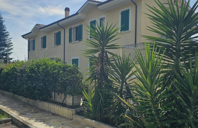 Palazzina del complesso residenziale con giardino e piante
