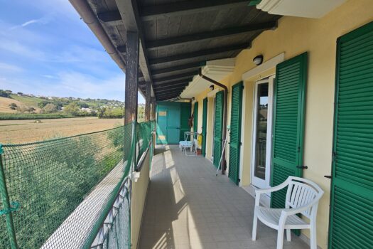 Terrazza lungo la facciata con persiane verdi, complesso Le File