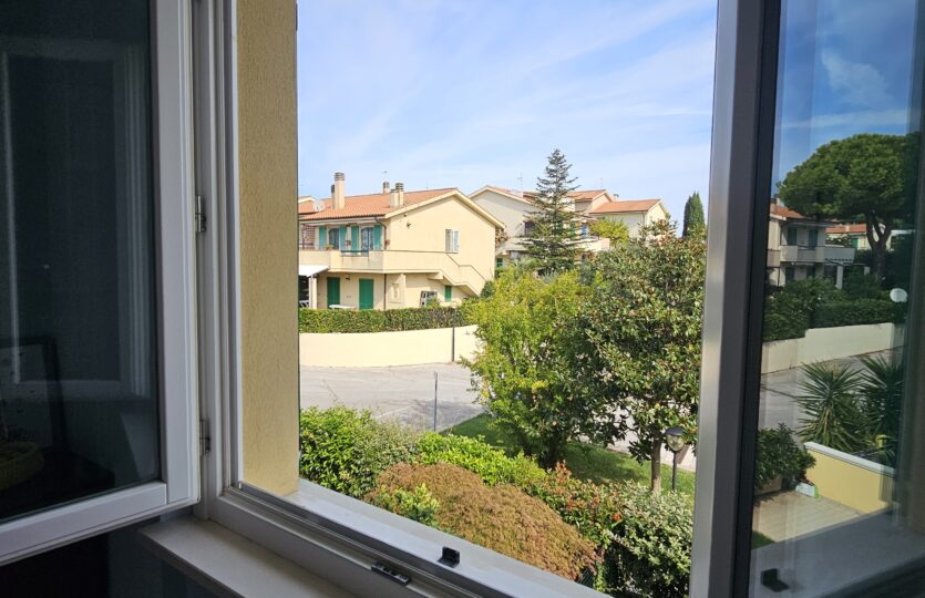 Finestra con vista sul verde e sulle case vicine