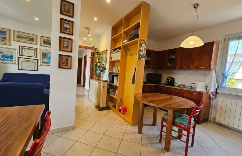 Zona pranzo del soggiorno con libreria in legno e tavolo